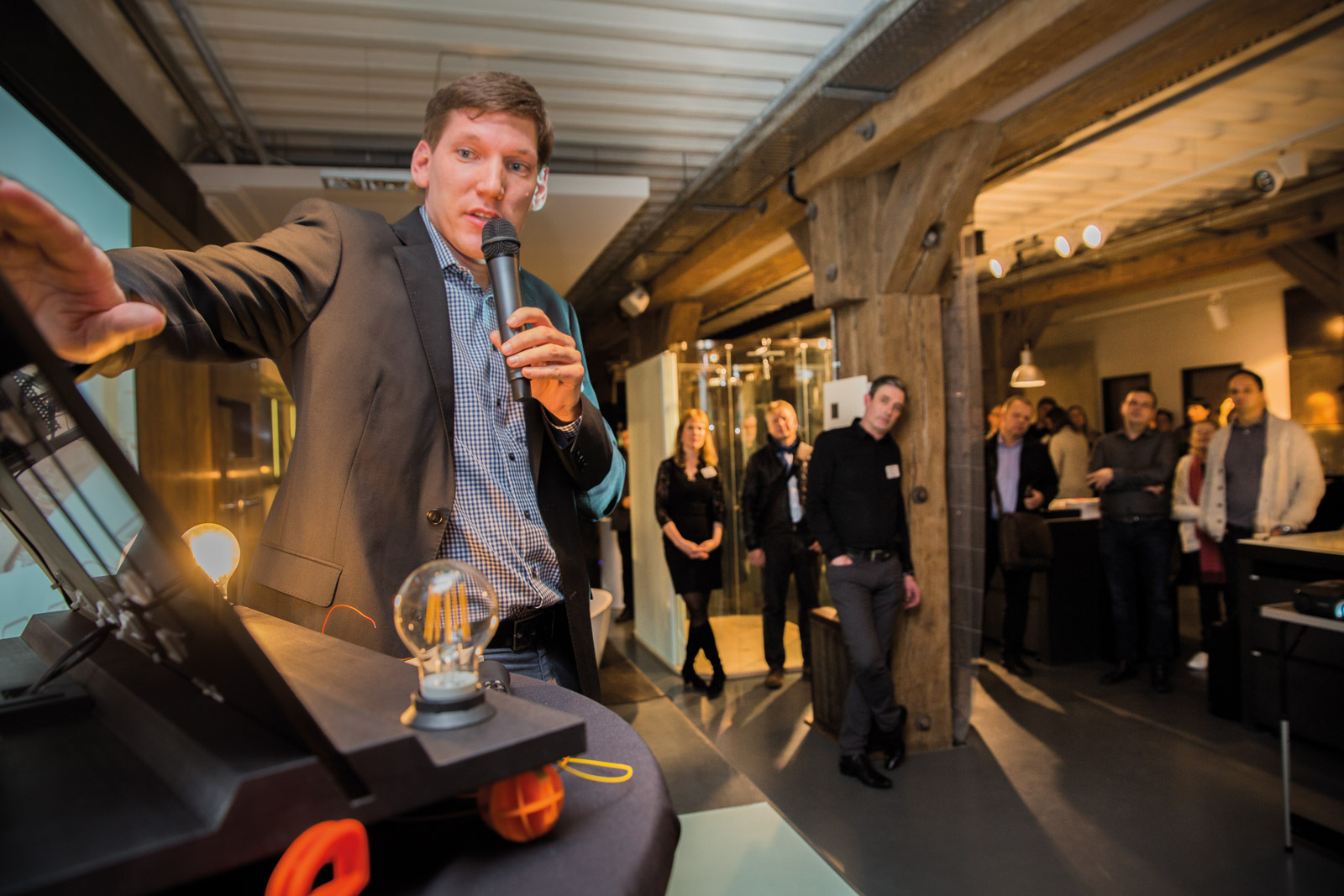 En man visar innovativ belysningsteknik i Hamburg medan publiken lyssnar uppmärksamt.