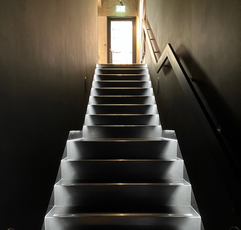 Die Treppe ins Licht – Nach oben geht es in die Gallery, unten geht es zum Schulungs-Hub und in die Hörräume.