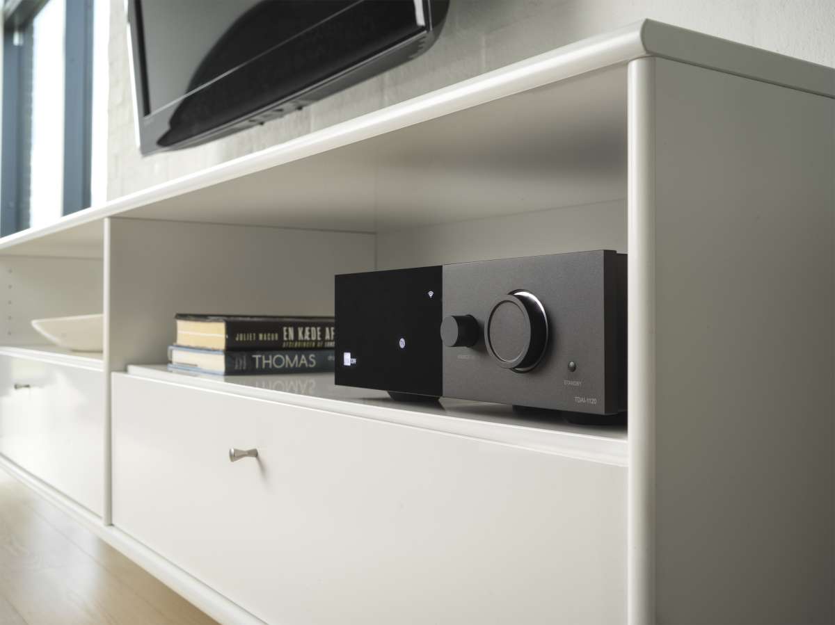 Lyngdorf TDAI-1120 streamingförstärkare i modernt vardagsrum, kombinerar stilren design med imponerande ljudkvalitet.