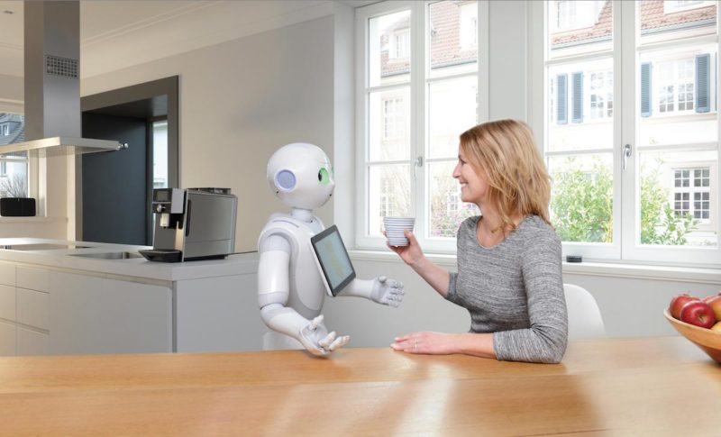 En robot serverar kaffe till en kvinna i ett modernt smart hem.