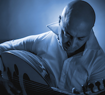 En musiker spelar oud passionerat under blått ljus vid Münster Music Days 2014.