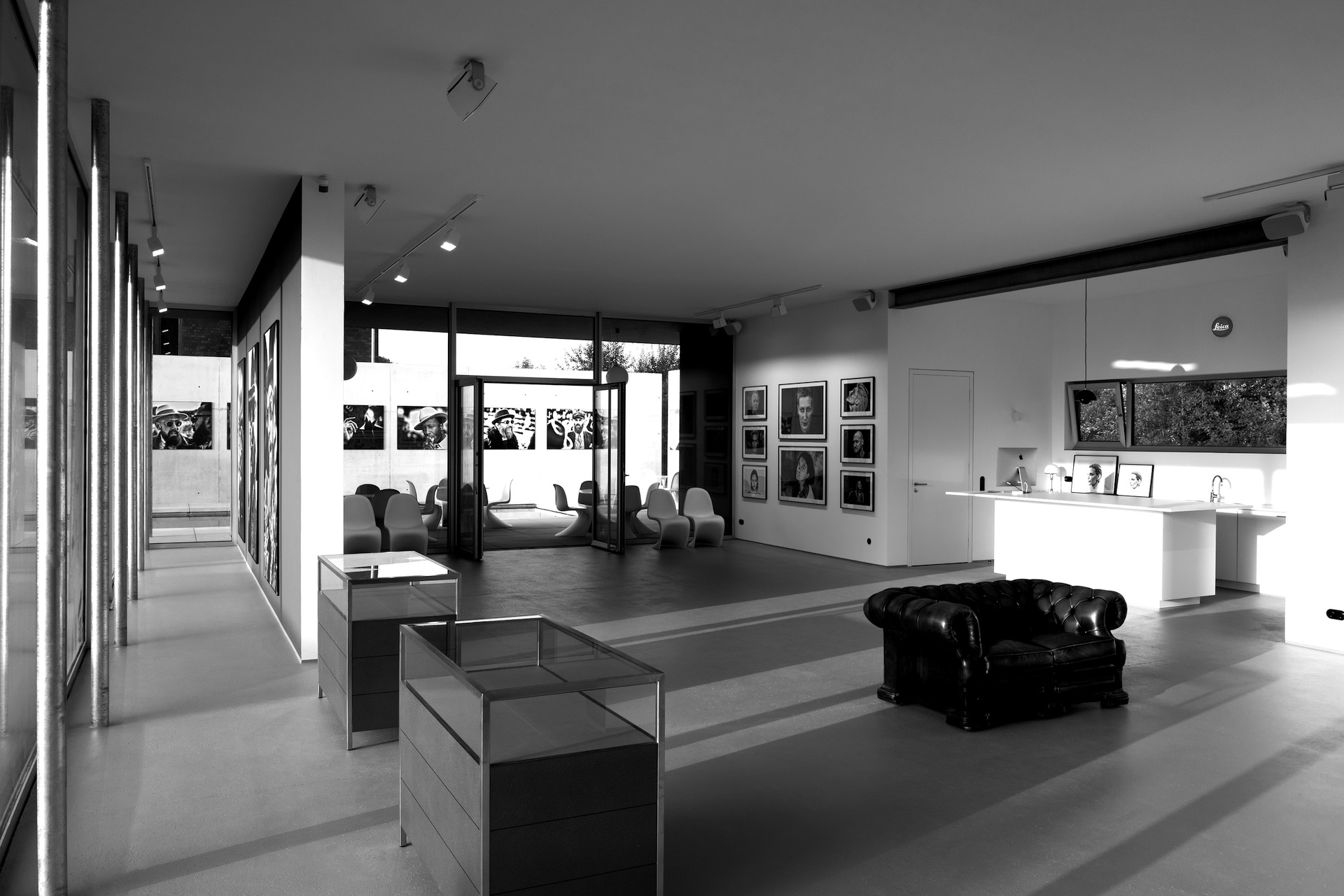 En elegant, monokrom konstgalleri med moderna sittplatser och stilfulla fotografier på väggarna.