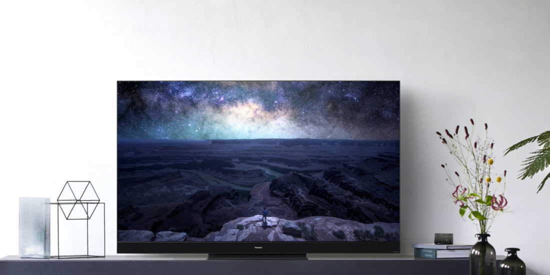 Ett modernt vardagsrum med en stor TV som visar en stjärnklar himmel, perfekt för hemmabio.